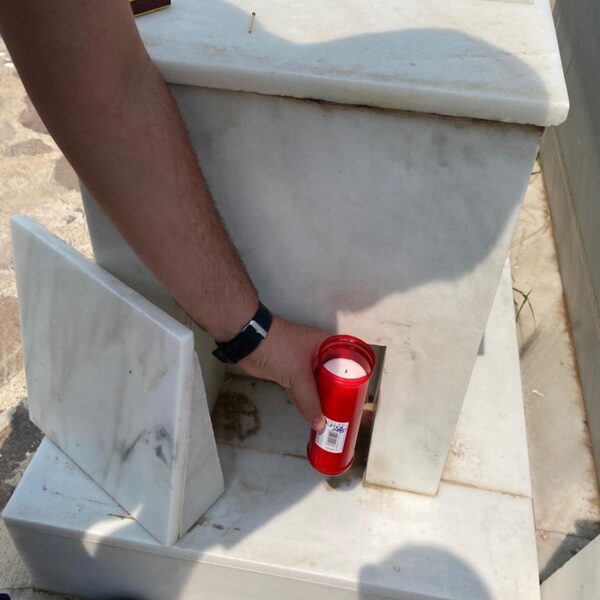 Placement of a lit candle on the grave